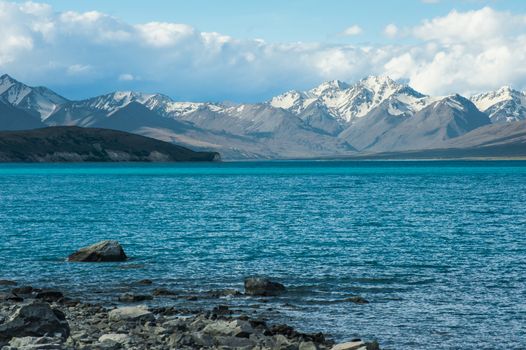 Beautiful incredibly blue lake Tekapo with  mountains, Southern Alps, on the other side. New Zealand