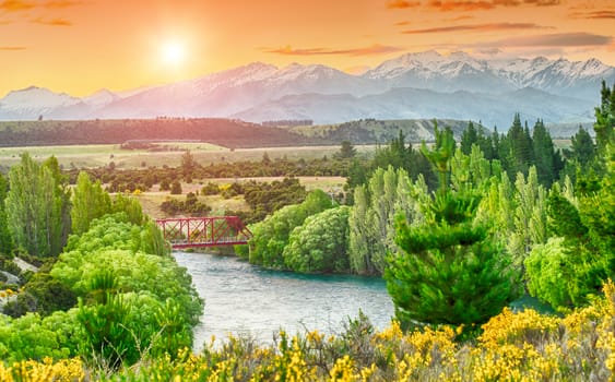 Beautiful sunset over the bend of the river Clutha with Southern Alps peaks on the horizon, New Zealand