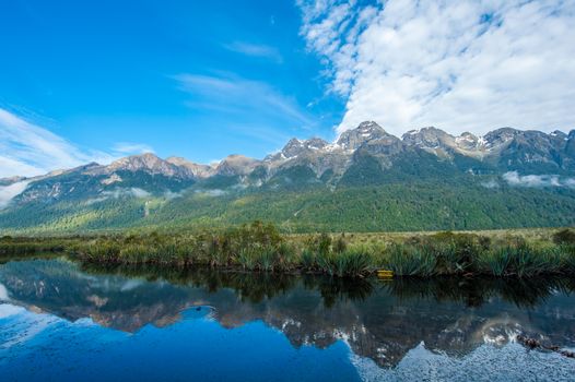 Mirror Lakes are a famous natural landmark omn the Milford Road in the Fiordland National Park. Snowy mountains are reflecting in a calm water. New Zealand