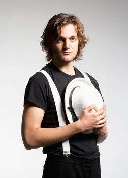 Portrait of a Young Man with Brown Hair Holding a White Hat