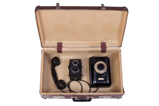 Old rotational phone and  film camera in an old suitcase