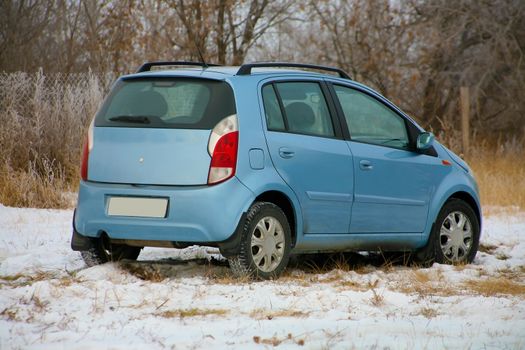  car of blue colour on a snow-covered glade