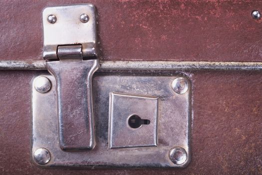 Detail of an old brown suitcase with the lock
