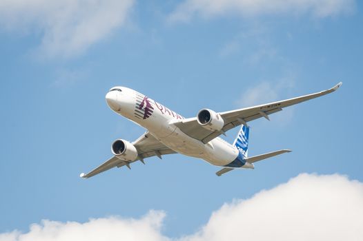 Farnborough, UK - July 14, 2014: The newly developed Airbus A350 in Qatar Airways livery, in the skies above Farnborough airport, UK