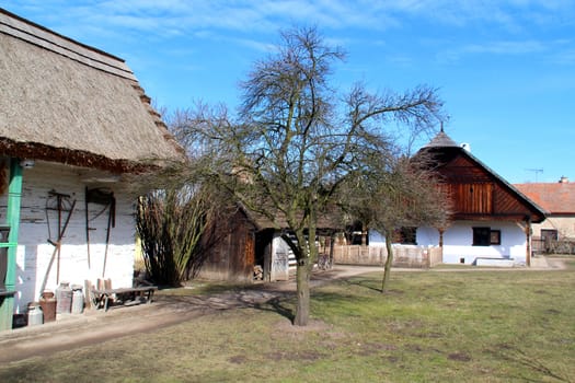 Photo shows old village houses and their surroundings..