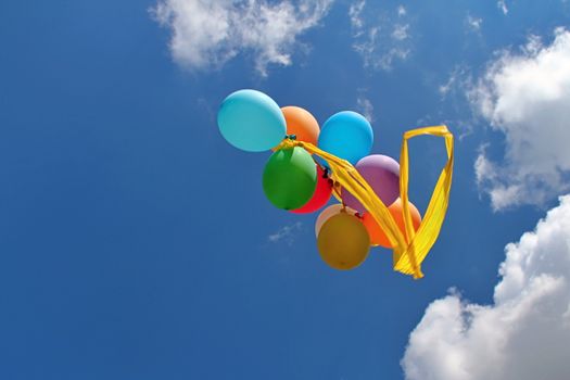 Photo shows colourful balloons in the sky.