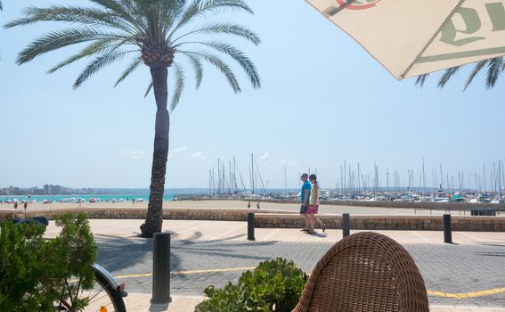 Street scene Can Pastilla with bikes and ocean view. Mallorca, Balearic islands, Spain in July.