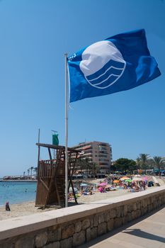 Blue flag on beach. Cala Estancia, Mallorca, Balearic islands, Spain in July.