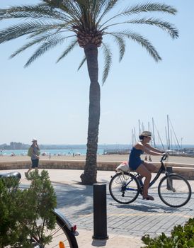 Street scene Can Pastilla with bikes and ocean view. Mallorca, Balearic islands, Spain in July.