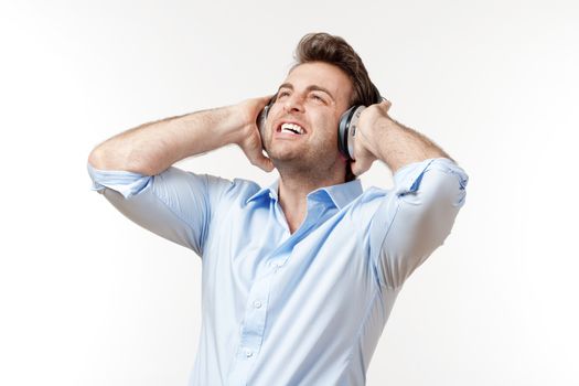 man in blue shirt with earphones listening to music - isolated on white