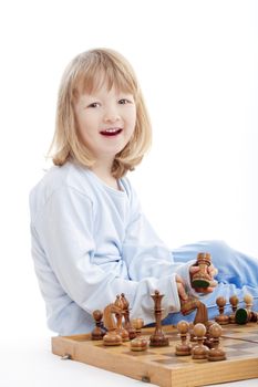 boy with long blond hair playing with chess pieces - isolated on white