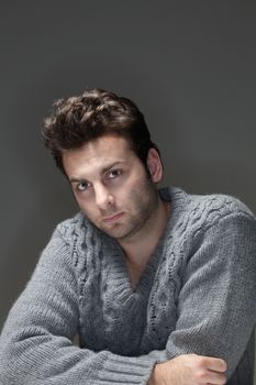 portrait of a man in a sweater looking at camera - isolated on gray