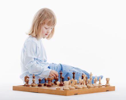 boy with long blond hair playing with chess pieces - isolated on white