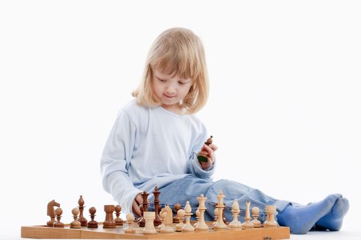 boy with long blond hair playing with chess pieces - isolated on white