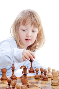 boy with long blond hair playing with chess pieces - isolated on white