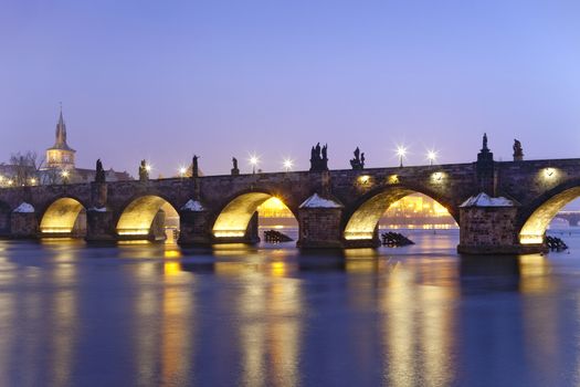 czech republic prague - illuminated charles bridge at dusk in winter