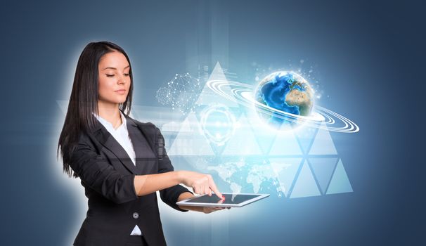 Beautiful businesswomen in suit using digital tablet. Earth with triangles and network. Element of this image furnished by NASA