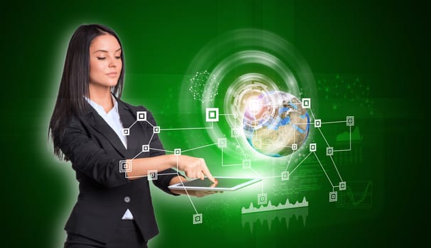 Beautiful businesswomen in suit using digital tablet. Earth with network, graphs and circles. Element of this image furnished by NASA