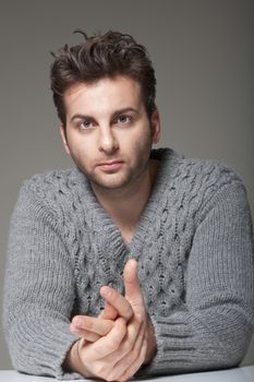 portrait of a man in a sweater looking at camera - isolated on gray