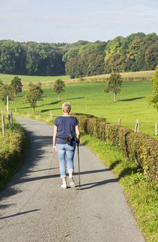 woman walking in nature with bottle of water on her back