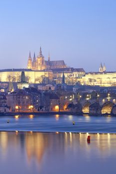 prague in winter - charles bridge and hradcany castle at dusk