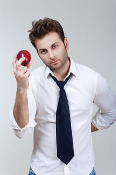 man in white shirt and tie holding red apple looking - isolated on gray