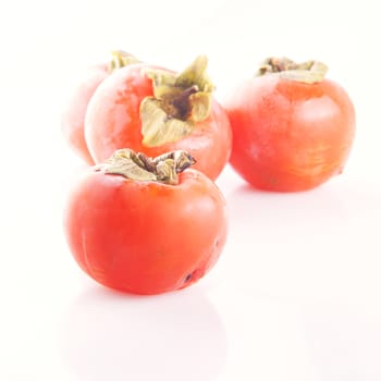 Fruits of persimmon isolated over white, Three defocused on the back