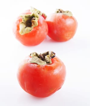 Fruits of persimmon isolated over white, two defocused on the back