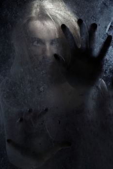 Female witch behind the dark glass
