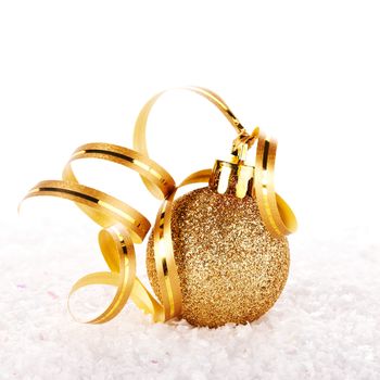 New Year's golden ball on snow with a tape. New Year's golden balls. Christmas balls. Christmas tree decorations. Christmas jewelry.