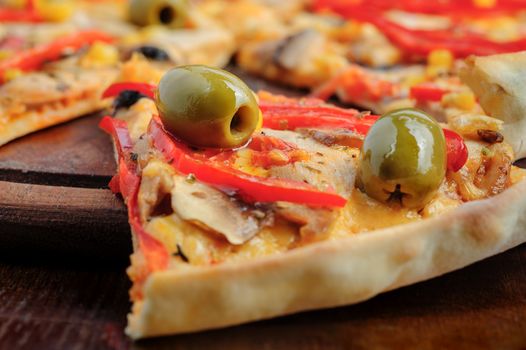 Macro closeup of pizza with mozzarella, mushrooms, olives and red bell pepper