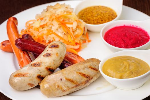German bawarian roasted sausages with stewed cabbage and sauces
