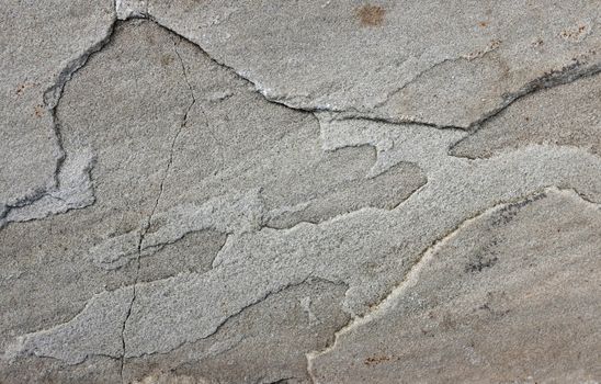 Uneven grey sandstone slab as abstract background texture