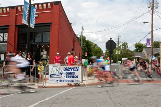 Duluth, GA, USA - August 2, 2014:  Cyclists motion blur heading into a turn as they compete in the Georgia Cup, a criterium event held on the streets of downtown Duluth.