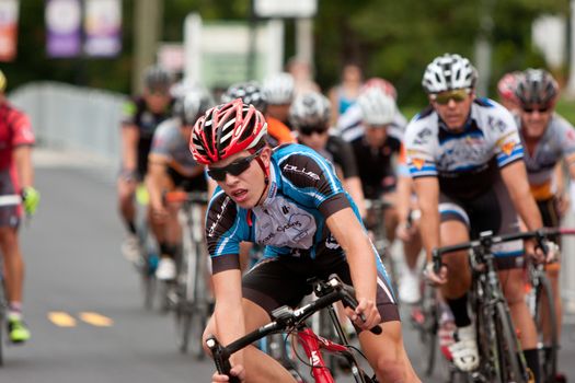 Duluth, GA, USA - August 2, 2014:  Amateur cyclists race into a turn on a downtown Duluth street as they compete in the Georgia Cup Criterium event.