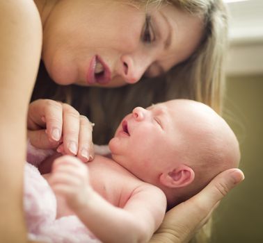 Young Caucasian Beautiful Mother Holding Her Precious Newborn Baby Girl.