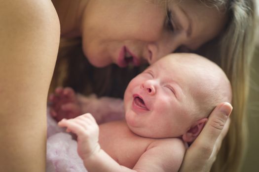 Young Caucasian Beautiful Mother Holding Her Precious Newborn Baby Girl.