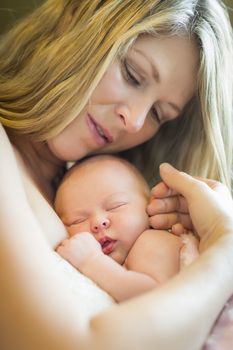 Young Caucasian Beautiful Mother Holding Her Precious Newborn Baby Girl.