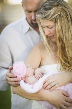 Beautiful Young Couple Holding Their Newborn Baby Girl Outside.