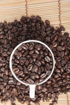 Coffee beans in coffee cup on table wooden.