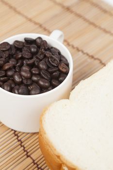 Bread plate and cup with coffee beans.on table wooden pack-shot in studio.