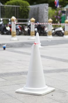 White traffic cone Located on ground to tell the parking area.
