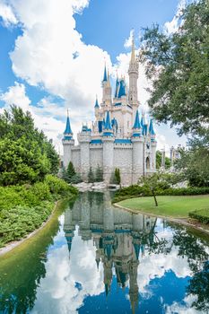 Orlando, Florida – Sept 4: The famous Disney Magic Kingdom Castle and its mirror reflection on the calm waters surrounding the castle in Orlando, Florida, on September 4, 2014