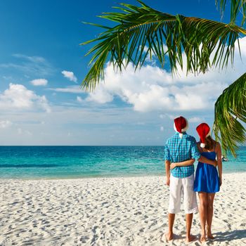 Couple in blue clothes on a tropical beach at christmas