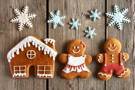 Christmas homemade gingerbread couple and house on wooden table