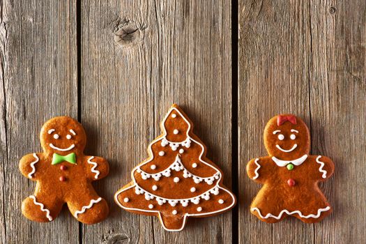 Christmas homemade gingerbread couple and tree on wooden table