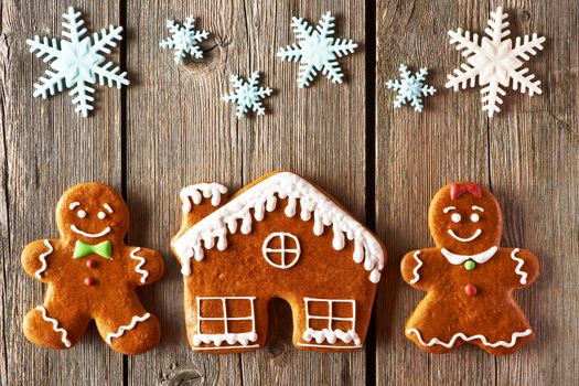 Christmas homemade gingerbread couple and house on wooden table