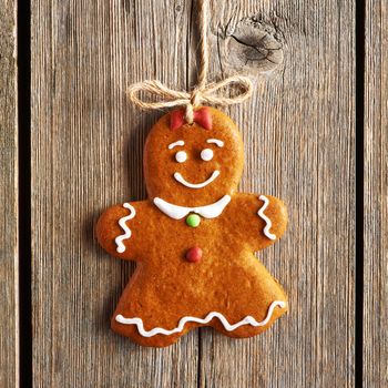 Christmas homemade gingerbread girl over wooden background
