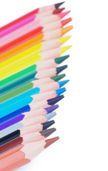 Border of Multicolored Pencils In a Row isolated on white background. Focus on Foreground