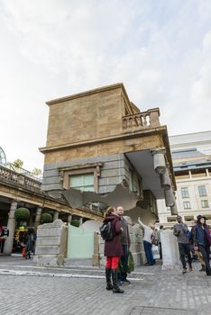 LONDON, UK - OCTOBER 05: Tourist observing artwork by artist Alex Chinneck in Covent Garden. The floating piazza will remain there until the end of the month. October 05, 2014 in London.